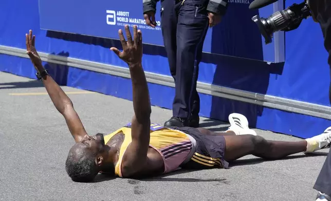 Sisay Lemma, of Ethiopia, celebrates while lying down after winning the Boston Marathon, Monday, April 15, 2024, in Boston. (AP Photo/Steven Senne)