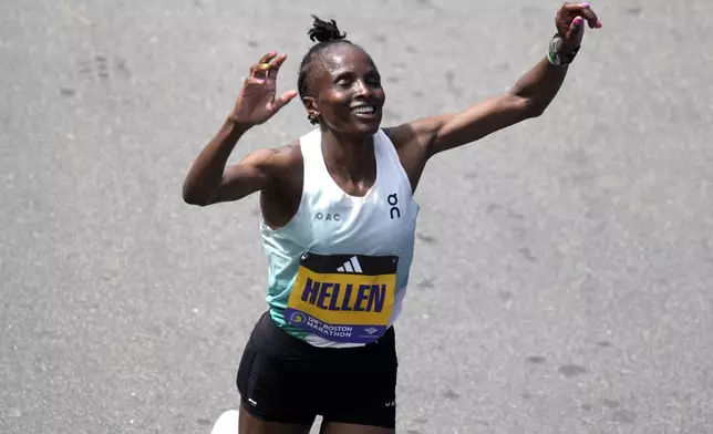 Hellen Obiri, of Kenya, raises her arms after winning the women's division at the Boston Marathon, Monday, April 15, 2024, in Boston. (AP Photo/Charles Krupa)