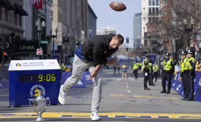 Former New England Patriots NFL football player Rob Gronkowski spikes a football on the finish line at the Boston Marathon, Monday, April 15, 2024, in Boston. Gronkowski is grand marshal of the race. (AP Photo/Steven Senne)