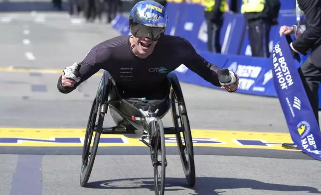 Marcel Hug, of Switzerland, celebrates as he wins the men's wheelchair division of the Boston Marathon, Monday, April 15, 2024, in Boston. (AP Photo/Steven Senne)