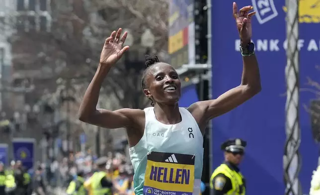 Hellen Obiri, of Kenya, celebrates after crossing the finish line to win the women's division at the Boston Marathon, Monday, April 15, 2024, in Boston. (AP Photo/Steven Senne)