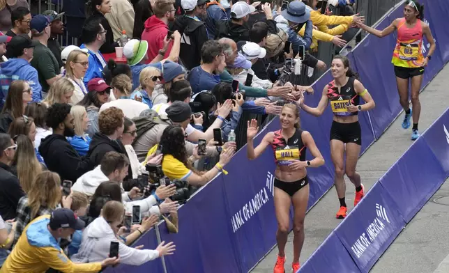 American women finishers celebrate with the crowd at the Boston Marathon, Monday, April 15, 2024, in Boston. At right are Sara Hall, Emma Bates and Des Linden. (AP Photo/Charles Krupa)