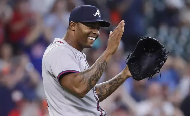 Atlanta Braves closing pitcher Raisel Iglesias celebrates after a baseball game against the Houston Astros, Wednesday, April 17, 2024, in Houston. The Braves won 5-4 in 10 innings. (AP Photo/Michael Wyke)