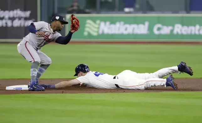Houston Astros' Kyle Tucker, right, safely steals second base as Atlanta Braves second baseman Ozzie Albies is last with the tag during the first inning of a baseball game, Monday, April 15, 2024, in Houston. (AP Photo/Michael Wyke)