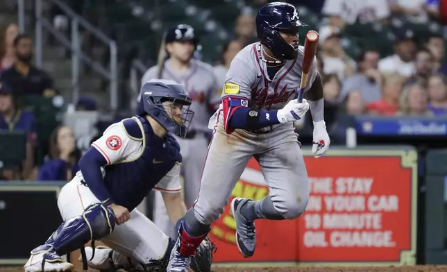 Atlanta Braves's Michael Harris II, right, flips his bat in front of Houston Astros catcher Yainer Diaz as he watches his RBI single during the ninth inning of a baseball game Monday, April 15, 2024, in Houston. (AP Photo/Michael Wyke)