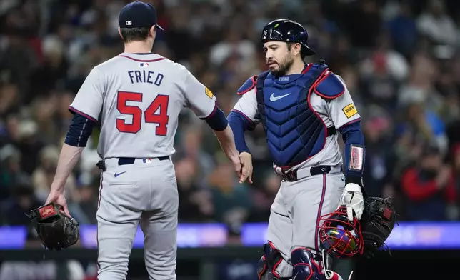 Atlanta Braves starting pitcher Max Fried (54) is greeted by catcher Travis d'Arnaud, right, after throwing out Seattle Mariners' Luis Urías at first base to end the fifth inning of a baseball game Monday, April 29, 2024, in Seattle. (AP Photo/Lindsey Wasson)