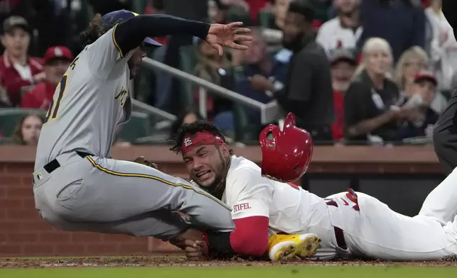St. Louis Cardinals' Willson Contreras is tagged out by Milwaukee Brewers starting pitcher Freddy Peralta, left, at home during the second inning of a baseball game Friday, April 19, 2024, in St. Louis. (AP Photo/Jeff Roberson)