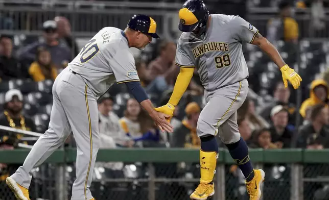 Milwaukee Brewers' Gary Sanchez, right, celebrates with third base coach Jason Lane as he runs the bases after hitting a home run during the eighth inning of the team's baseball game against the Pittsburgh Pirates on Tuesday, April 23, 2024, in Pittsburgh. (AP Photo/Matt Freed)