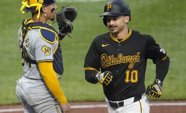 Pittsburgh Pirates' Bryan Reynolds (10) crosses home plate past Milwaukee Brewers catcher William Contreras after hitting a two-run home run off starting pitcher Bryse Wilson during the third inning of a baseball game in Pittsburgh, Wednesday, April 24, 2024. (AP Photo/Gene J. Puskar)