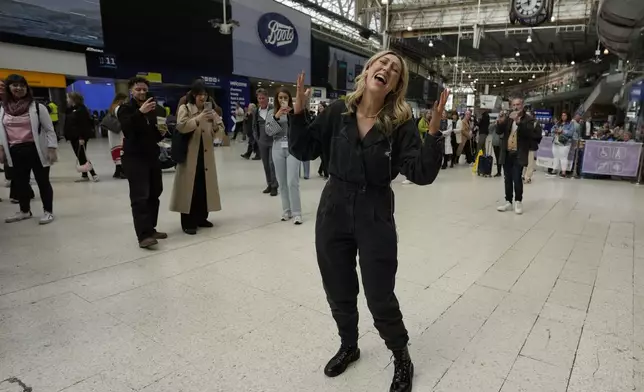Members of the Mark de Lisser singers preform the iconic ABBA song 'Waterloo' at Waterloo Station in London, Saturday, April 6, 2024. Fans are celebrating 50 years since ABBA won its first big battle with “Waterloo.” A half century ago on Saturday, April 6, the Swedish quartet triumphed at the 1974 Eurovision Song Contest with the peppy love song. (AP Photo/Alastair Grant)
