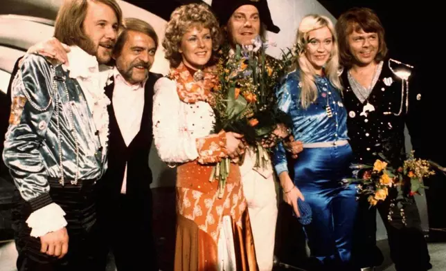 FILE - Members of Swedish group ABBA and close associates celebrate the victory of their song "Waterloo" in the Eurovision Song Contest in Brighton, England, April 6, 1974. Fans are celebrating 50 years since ABBA won its first big battle with “Waterloo.” A half century ago on Saturday, April 6, the Swedish quartet triumphed at the 1974 Eurovision Song Contest with the peppy love song. (AP Photo/File)
