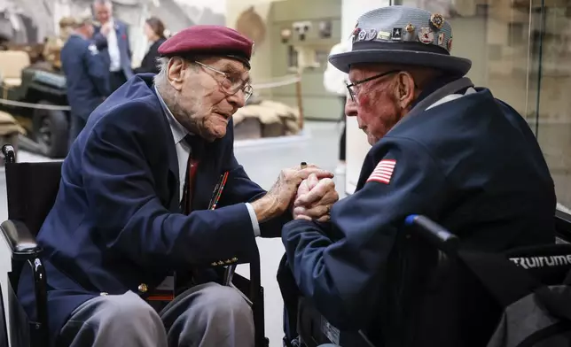 FILE - World War II veteran Britain's Bill Gladden, left, speaks with U.S WWII veteran Jack M. Larson in the Pegasus Bridge memorial in Benouville, Normandy, Monday June 5, 2023. Gladden, one of the dwindling number of veterans who took part in the landings that kicked off the campaign to liberate Western Europe from the Nazis during World War II, died Wednesday, April 24, 2024, his family said. He was 100. (AP Photo/Thomas Padilla, File)