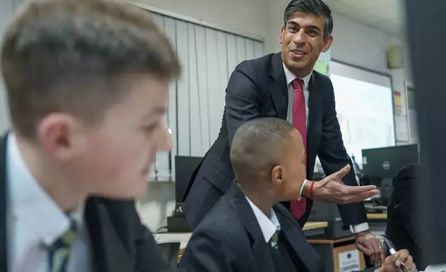 FILE - Britain's Prime Minister Rishi Sunak meets students taking part in a personal development lesson as he visits Haughton Academy to outline plans for the banning of single use vapes, in Darlington, England, on Jan. 29, 2024. British lawmakers will on Tuesday April 16, 2024 debate and vote on the government's plans to introduce a landmark smoking ban that aims to stop young people from ever smoking. (Ian Forsyth/Pool Photo via AP, File)