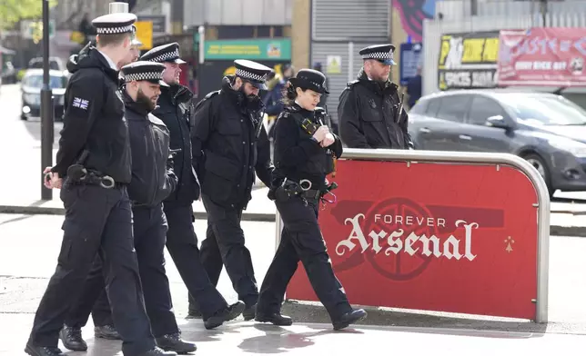 Police arrive to patrol outside Arsenal's Emirates Stadium ahead of the Champions League quarterfinal 1st leg soccer match between Arsenal and Bayern Munich in London, Tuesday, April 9, 2024. This week's Champions League soccer games will go ahead as scheduled despite an Islamic State terror threat. (AP Photo/Frank Augstein)