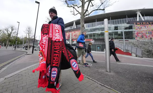 A memorabilia vendor outside Arsenal's Emirates Stadium ahead of the Champions League quarterfinal 1st leg soccer match between Arsenal and Bayern Munich in London, Tuesday, April 9, 2024. This week's Champions League soccer games will go ahead as scheduled despite an Islamic State terror threat. (AP Photo/Frank Augstein)