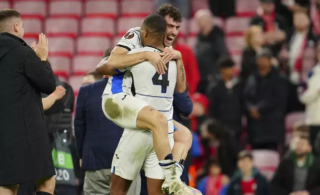 Atalanta's Isak Hien, front, and Matteo Ruggeri celebrate after beating 3-0 Liverpool during the Europa League quarter final first leg soccer match at the Anfield stadium in Liverpool, England, Thursday, April 11, 2024. (AP Photo/Jon Super)