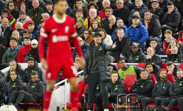 Liverpool's manager Jurgen Klopp, back, gestures during the Europa League quarter final first leg soccer match between Liverpool and Atalanta, at the Anfield stadium in Liverpool, England, Thursday, April 11, 2024. (AP Photo/Jon Super)