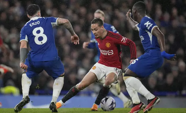 Manchester United's Antony, center, is challenged by Chelsea's Enzo Fernandez, left, and Chelsea's Moises Caicedo during the English Premier League soccer match between Chelsea and Manchester United at Stamford Bridge in London, Thursday, April 4, 2024. (AP Photo/Kin Cheung)