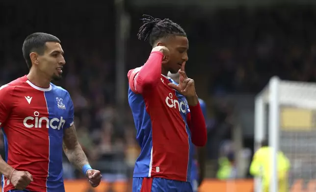 Crystal Palace's Michael Olise, right, celebrates scoring their first goal of the game during the English Premier League soccer match between West Ham United and Crystal Palace at Selhurst Park in London, Sunday April 21, 2024. (Steven Paston/PA via AP)