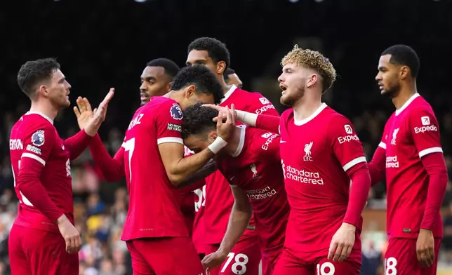 Liverpool's Diogo Jota celebrates with teammates after scoring his side's third goal during the English Premier League soccer match between Fulham and Liverpool at Craven Cottage stadium in London, Sunday, April 21, 2024. (AP Photo/Kirsty Wigglesworth)