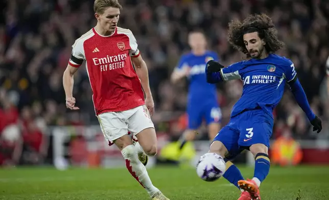 Arsenal's Martin Odegaard, left, tries to block a shot from Chelsea's Marc Cucurella during the English Premier League soccer match between Arsenal and Chelsea at Emirates Stadium in London, Tuesday, April 23, 2024. (AP Photo/Kin Cheung)