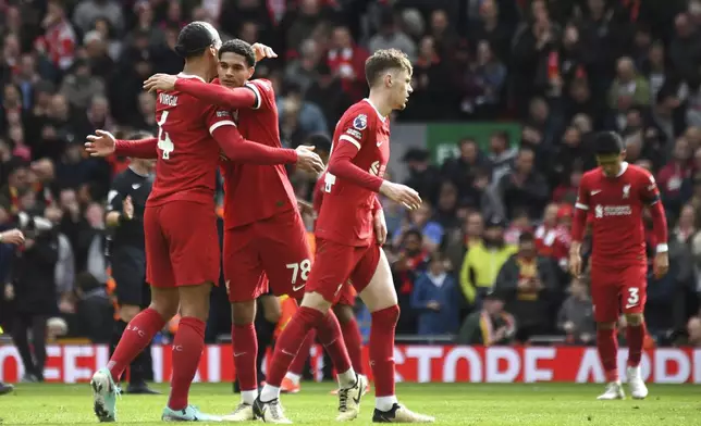 Liverpool's Virgil van Dijk, left, and Liverpool's Jarell Quansah celebrate their victory at the English Premier League soccer match between Liverpool and Brighton and Hove at Anfield Stadium in Liverpool, England, Sunday, March 31, 2024. (AP Photo/Rui Vieira)