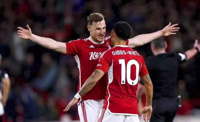 Nottingham Forest's Chris Wood, left, celebrates with team-mate Morgan Gibbs-White after scoring their side's second goal during the English Premier League soccer match between Nottingham Forest and Fulham at the City Ground, in Nottingham, England, Tuesday, April 2, 2024. (Bradley Collyer/PA via AP)