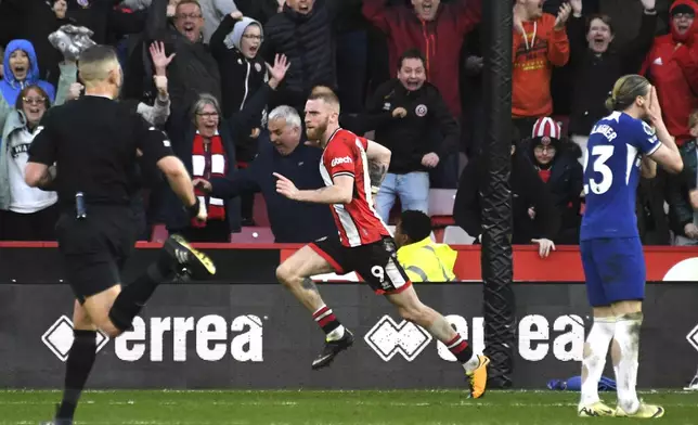 Sheffield United's Oli McBurnie, centre, celebrates after scoring his side's second goal during the English Premier League soccer match between Sheffield United and Chelsea at Bramall Lane stadium in Sheffield, England, Sunday, April 7, 2024. (AP Photo/Rui Vieira)