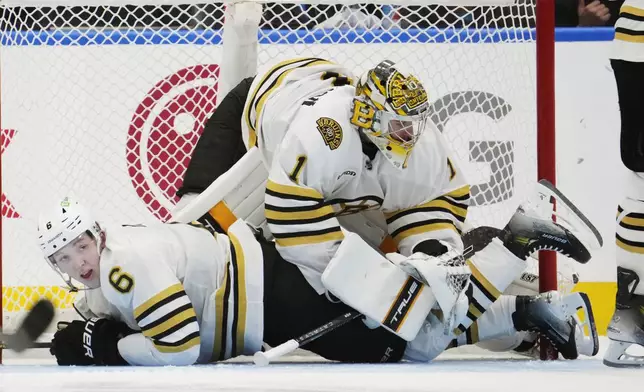 Boston Bruins goaltender Jeremy Swayman (1) falls over Mason Lohrei (6) during the third period in Game 4 of the team's NHL hockey Stanley Cup first-round playoff series against the Toronto Maple Leafs in Toronto on Saturday, April 27, 2024. (Frank Gunn/The Canadian Press via AP)