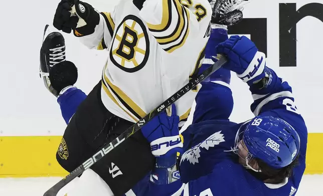Boston Bruins' Brad Marchand (63) checks Toronto Maple Leafs' Tyler Bertuzzi (59) during first-period action in Game 4 of an NHL hockey Stanley Cup first-round playoff series in Toronto, Saturday, April 27, 2024. (Nathan Denette/The Canadian Press via AP)
