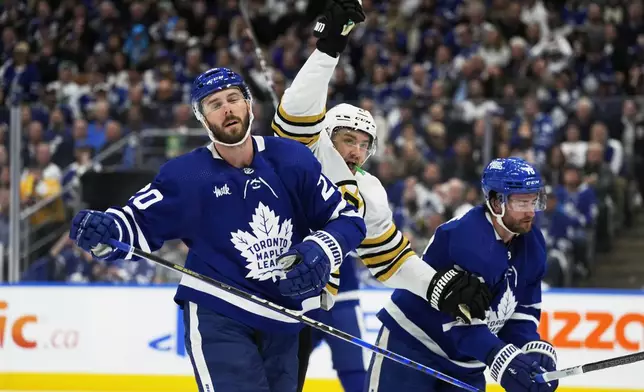 Boston Bruins' James van Riemsdyk, center, celebrates his goal as Toronto Maple Leafs' Joel Edmundson (20) and TJ Brodie (78) react during the first period in Game 4 of an NHL hockey Stanley Cup first-round playoff series in Toronto on Saturday, April 27, 2024. (Frank Gunn/The Canadian Press via AP)