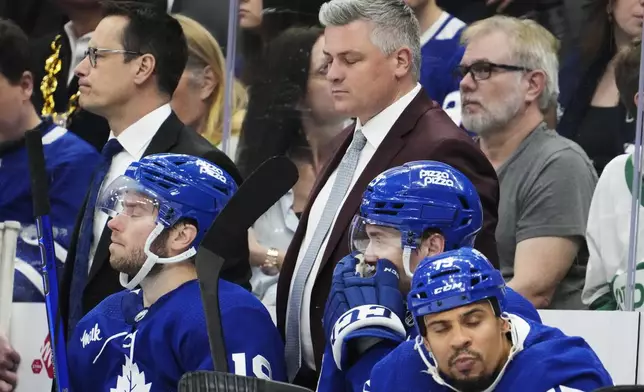 Toronto Maple Leafs head coach Sheldon Keefe, top front right, reacts on the bench with, from bottom left to right, Calle Jarnkrok, Pontus Holmberg and Ryan Reaves during third-period action against the Boston Bruins in Game 4 of an NHL hockey Stanley Cup first-round playoff series in Toronto, Saturday, April 27, 2024. (Frank Gunn/The Canadian Press via AP)