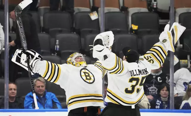 Boston Bruins goaltender Jeremy Swayman, left, and goaltender Linus Ullmark, right, celebrate after defeating the Toronto Maple Leafs in Game 4 of an NHL hockey Stanley Cup first-round playoff series in Toronto, Saturday, April 27, 2024. (Frank Gunn/The Canadian Press via AP)