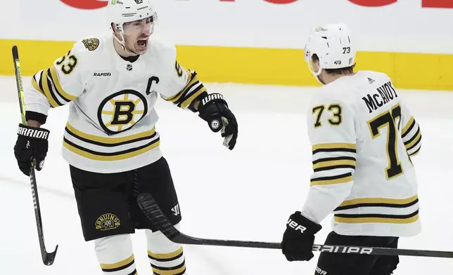 Boston Bruins' Brad Marchand (63) celebrates after his goal against the Toronto Maple Leafs with Charlie McAvoy (73) during second-period action in Game 4 of an NHL hockey Stanley Cup first-round playoff series in Toronto, Saturday, April 27, 2024. (Nathan Denette/The Canadian Press via AP)