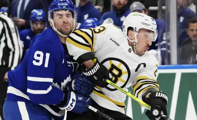 Toronto Maple Leafs' John Tavares (91) takes an elbow from Boston Bruins' Brad Marchand (63) during first-period action in Game 4 of an NHL hockey Stanley Cup first-round playoff series in Toronto, Saturday, April 27, 2024. (Frank Gunn/The Canadian Press via AP)