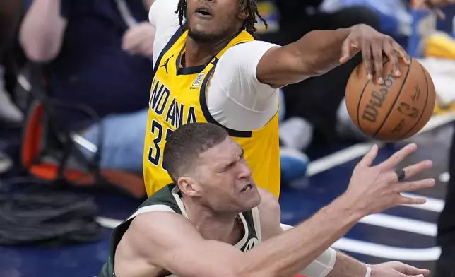 Indiana Pacers' Myles Turner (33) defends Milwaukee Bucks' Brook Lopez (11) during the second half of Game 4 of the first round NBA playoff basketball series, Sunday, April 28, 2024, in Indianapolis. (AP Photo/Michael Conroy)