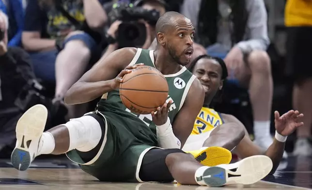 Milwaukee Bucks' Khris Middleton is defended by Indiana Pacers' Aaron Nesmith during the second half of Game 4 of the first round NBA playoff basketball series, Sunday, April 28, 2024, in Indianapolis. (AP Photo/Michael Conroy)