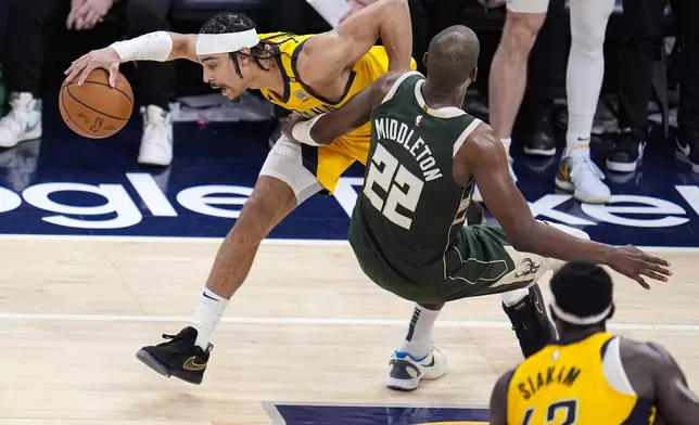Indiana Pacers guard Andrew Nembhard (2) is fouled by Milwaukee Bucks forward Khris Middleton (22) during the second half in Game 2 in an NBA basketball first-round playoff series, Friday, April 26, 2024, in Indianapolis. (AP Photo/Michael Conroy)