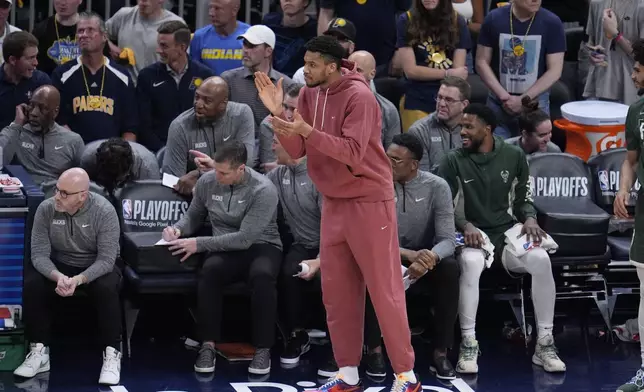 Milwaukee Bucks' Giannis Antetokounmpo cheers on his teammates during the first half of Game 4 of the first round NBA playoff basketball series against the Indiana Pacers, Sunday, April 28, 2024, in Indianapolis. (AP Photo/Michael Conroy)