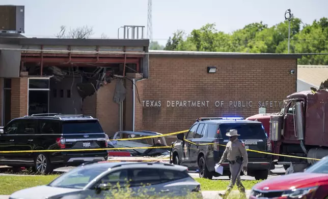 A stolen 18-wheeler crashed into a Texas Department of Public Safety office on US-290 in Brenham, Texas on Friday, April 12, 2024. The driver of a stolen semitrailer intentionally rammed it into the Texas public safety office in a rural town west of Houston on Friday, injuring multiple people, according to a state lawmaker. (Meredith Seaver/College Station Eagle via AP)