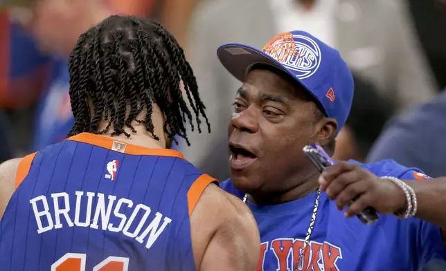New York Knicks guard Jalen Brunson, left, hugs actor Tracy Morgan after the Knicks beat the Chicago Bulls in overtime in an NBA basketball game Sunday, April 14, 2024, in New York. (AP Photo/John Munson)