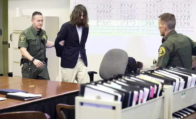 CORRECTS SOURCE - Orange County Deputy Sheriffs escort Samuel Woodward into Orange County Superior Court for opening statements of the murder trial for the stabbing death of Blaze Bernstein on Tuesday, April 9, 2024, in Santa Ana, Calif. (Frederick M. Brown via The Orange County Register, Pool)