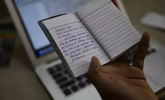 CORRECTS JOURNALIST'S FIRST NAME - Indian journalist Sidhique Kappan at his home in Kerala, India, shows notes from the diary he kept in prison, April 1, 2024. He was charged in 2020 on allegations of inciting violence while trying to report on a government clampdown in the northern Uttar Pradesh state ruled by the party of Prime Minister Narendra Modi. The time it takes to defend himself has made it difficult to work to support his family. (AP Photo/R S Iyer)