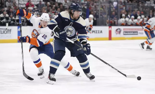 CORRECTS TO APRIL NOT MARCH - Columbus Blue Jackets defenseman Ivan Provorov (9) controls the puck as New York Islanders right wing Simon Holmstrom (10) defends during the first period of an NHL hockey game Thursday, April 4, 2024, in Columbus, Ohio. (AP Photo/Joe Maiorana)