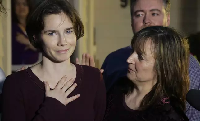 FILE - Amanda Knox, left, talks to reporters as her mother, Edda Mellas, right, looks on outside Mellas' home in Seattle, Friday, March 27, 2015. Amanda Knox faces yet another trial for slander in a case that could remove the last remaining guilty verdict against her nine years after Italy's highest court definitively threw out her conviction for the murder of her 21-year-old British roommate, Meredith Kercher. (AP Photo/Ted S. Warren, file)