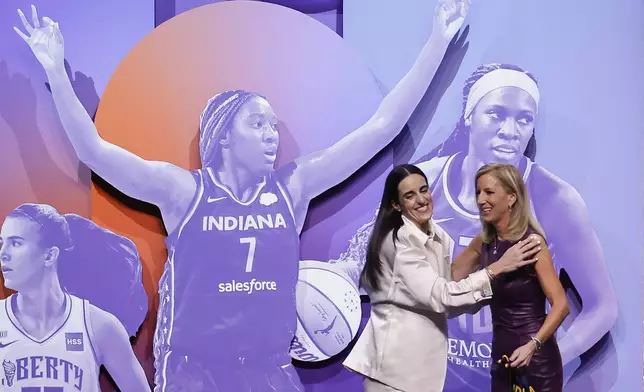 CORRECTS TO CAITLIN CLARK NOT CAITLYN CLARK - Iowa's Caitlin Clark, left, greets WNBA commissioner Cathy Engelbert, right, after being selected first overall by the Indiana Fever during the first round of the WNBA basketball draft, Monday, April 15, 2024, in New York. (AP Photo/Adam Hunger)
