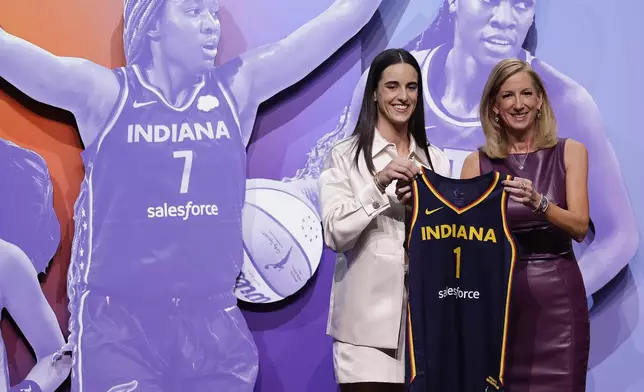 CORRECTS TO CAITLIN CLARK NOT CAITLYN CLARK - Iowa's Caitlin Clark, left, poses for a photo with WNBA commissioner Cathy Engelbert, right, after being selected first overall by the Indiana Fever during the first round of the WNBA basketball draft, Monday, April 15, 2024, in New York. (AP Photo/Adam Hunger)
