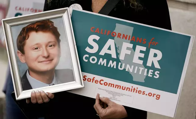Juli Shamash holds up a photo of her son, Tyler Shamash, who passed away from a fentanyl overdose in 2018, during a news conference organized by the Californians for Safer Communities Coalition, Thursday, April 18, 2024, in Culver City, Calif. The coalition, backed by retailers like Walmart and Target, announced Thursday it has collected enough signatures to put a ballot measure before California voters this November to enhance criminal penalties for shoplifting and drug dealing. (AP Photo/Ryan Sun)
