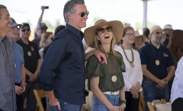 Gov. Gavin Newsom and first partner Jennifer Siebel Newsom laugh during a speech by Dolores Huerta during the dedication of the new Dos Rios State Park in the Central Valley, near Modesto, Calif., Monday, April 22, 2024. (Paul Kitagaki Jr./The Sacramento Bee via AP)
