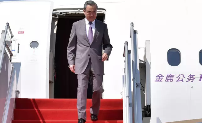 In this photo released by Agence Kampuchea Press (AKP), Chinese Foreign Minister Wang Yi arrives at Phnom Penh International Airport in Phnom Penh, Cambodia, Sunday, April 21, 2024. (AKP via AP)
